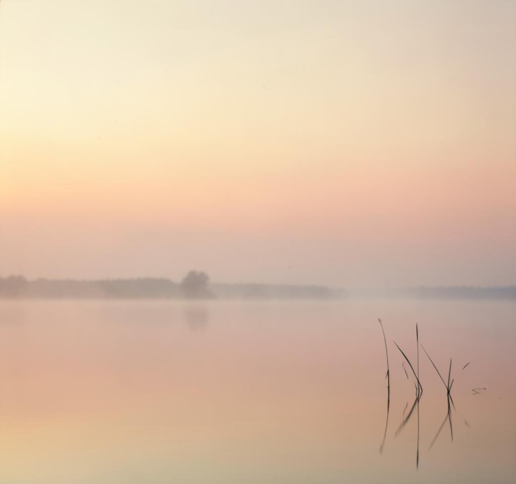 Lever de soleil calme au-dessus de l'eau, à l'aube